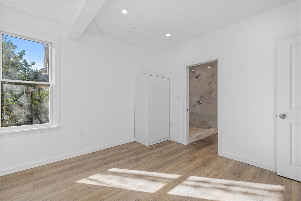 172 Lexington Avenue, Unit 1 Cambridge, MA 02138 - Photo 13 of 19 an empty room with wooden floor and windows