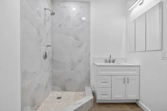 a bathroom with a bathtub a sink a vanity and a shower