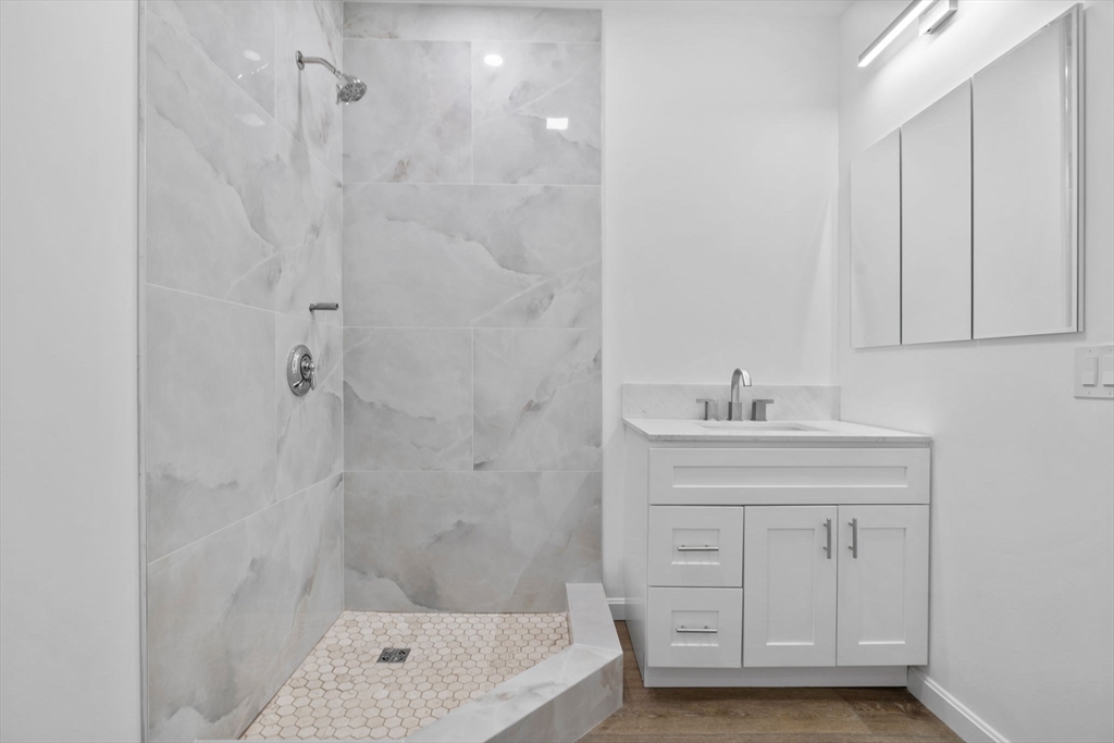 172 Lexington Avenue, Unit 1 Cambridge, MA 02138 - Photo 14 of 19 a bathroom with a bathtub a sink a vanity and a shower
