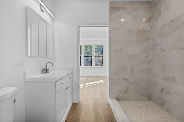 a bathroom with a sink a toilet and shower