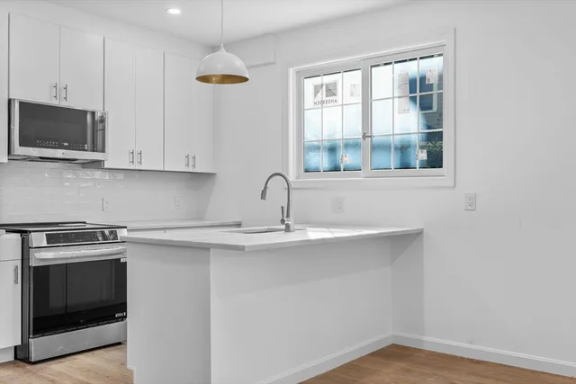 a kitchen with stainless steel appliances granite countertop a sink and a microwave
