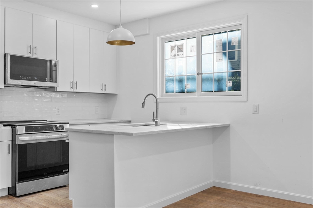 172 Lexington Avenue, Unit 1 Cambridge, MA 02138 - Photo 3 of 19 a kitchen with stainless steel appliances granite countertop a sink and a microwave