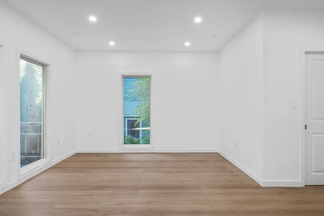 a view of empty room with wooden floor