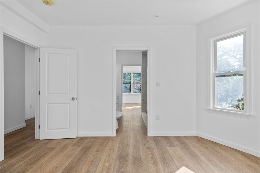 172 Lexington Avenue, Unit 1 Cambridge, MA 02138 - Photo 10 of 19 a view of an empty room with wooden floor and a window