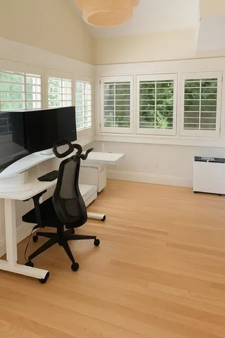 a view of a workspace with furniture and a window