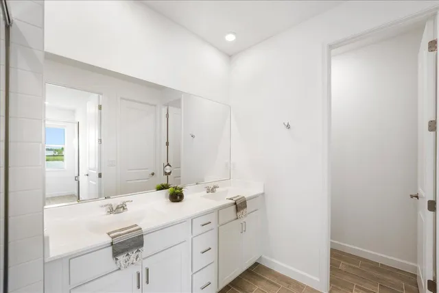 a bathroom with a double vanity sink and mirror