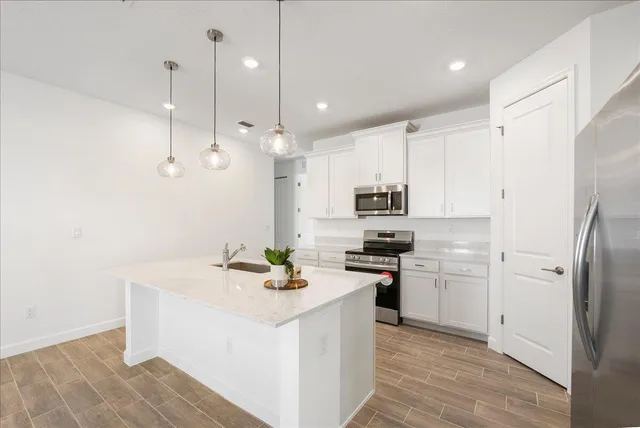 a kitchen with stainless steel appliances granite countertop a stove a sink and a refrigerator