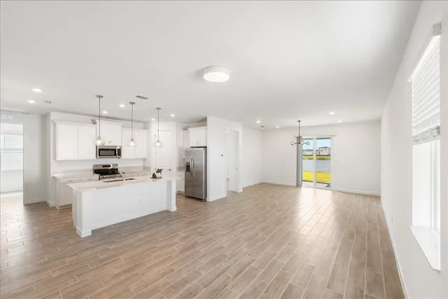 a kitchen with kitchen island a refrigerator and a cabinets