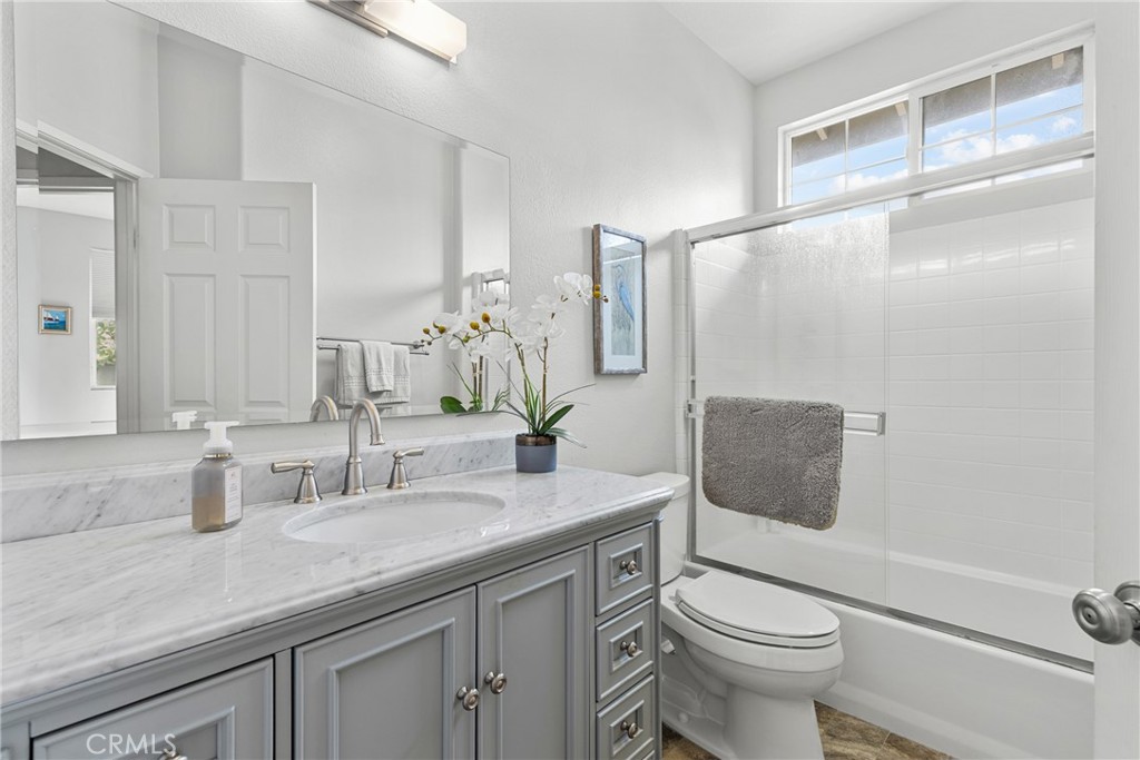 17823 Poplar Court Carson, CA 90746 - Photo 9 of 30 a bathroom with a granite countertop sink a toilet and a mirror