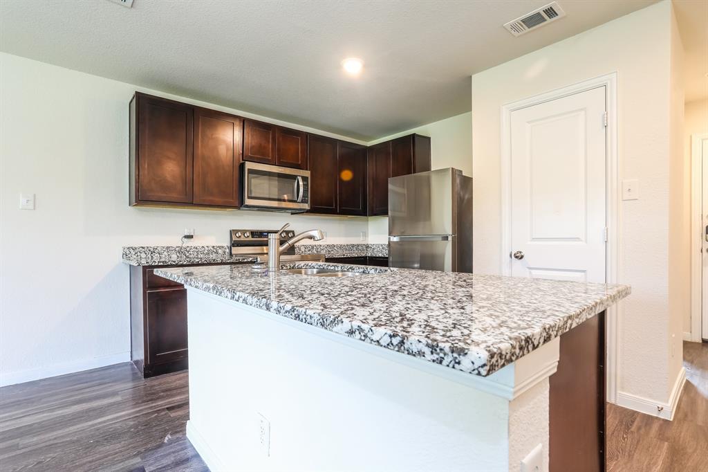 2515 Lyle Avenue Waco, TX 76708 - Photo 6 of 21 a kitchen with stainless steel appliances granite countertop a sink stove and refrigerator