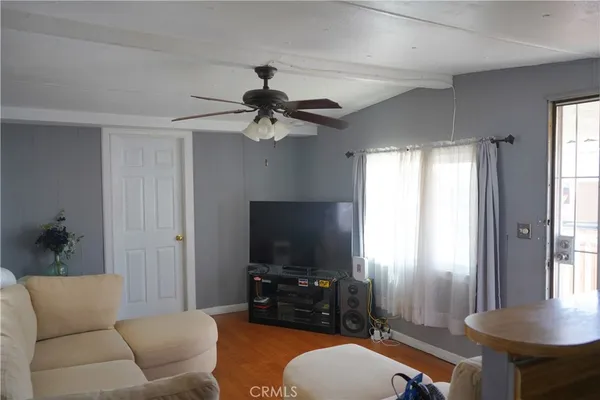 a living room with furniture a flat screen tv and a window