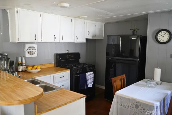 a kitchen with stainless steel appliances granite countertop a refrigerator a stove and white cabinets