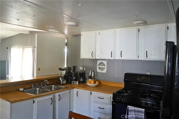 a kitchen with granite countertop a sink stove and cabinets