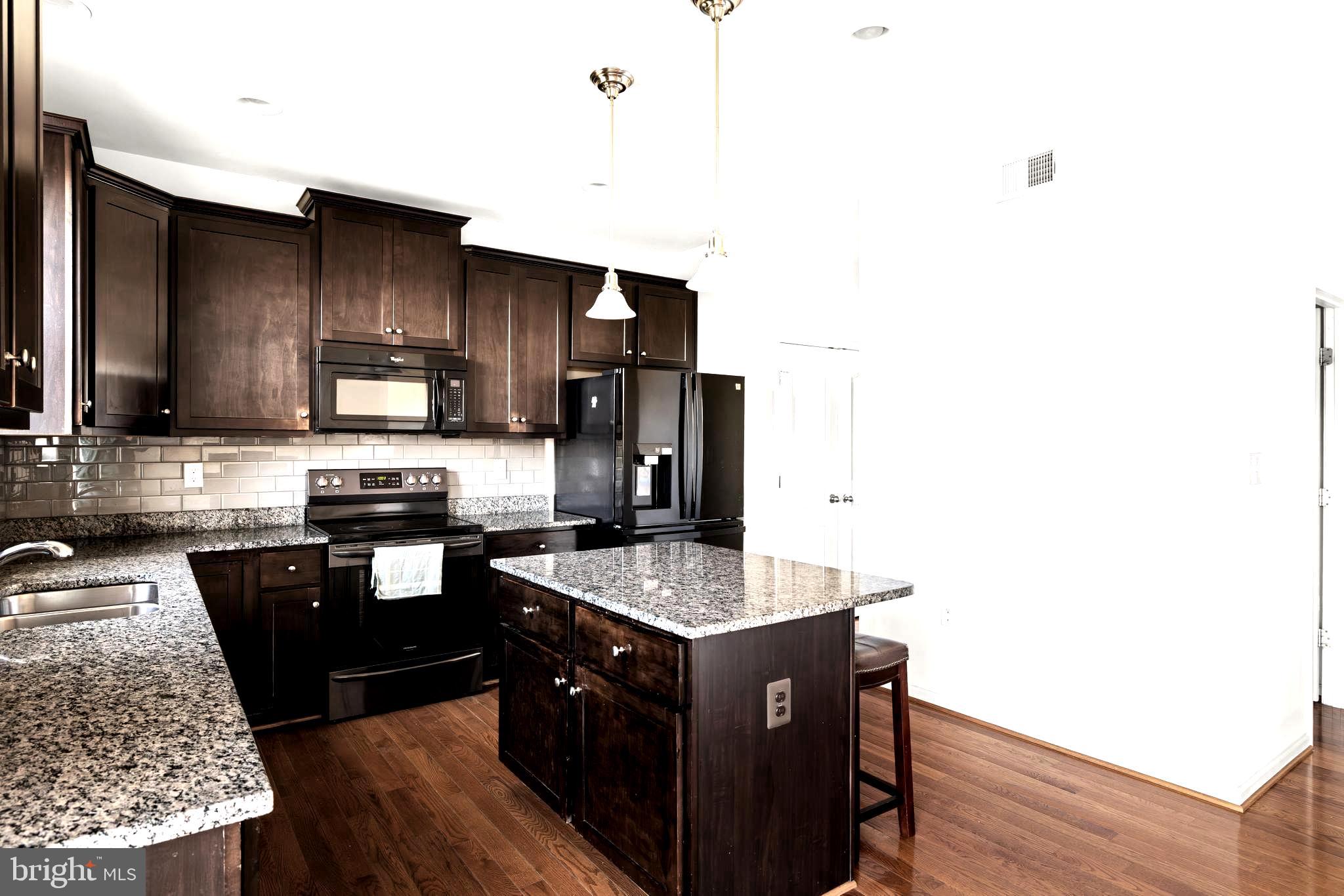 100 Taylor Court Stephenson, VA 22656 - Photo 8 of 36 a kitchen with granite countertop stainless steel appliances a sink a stove top oven a counter space and cabinets