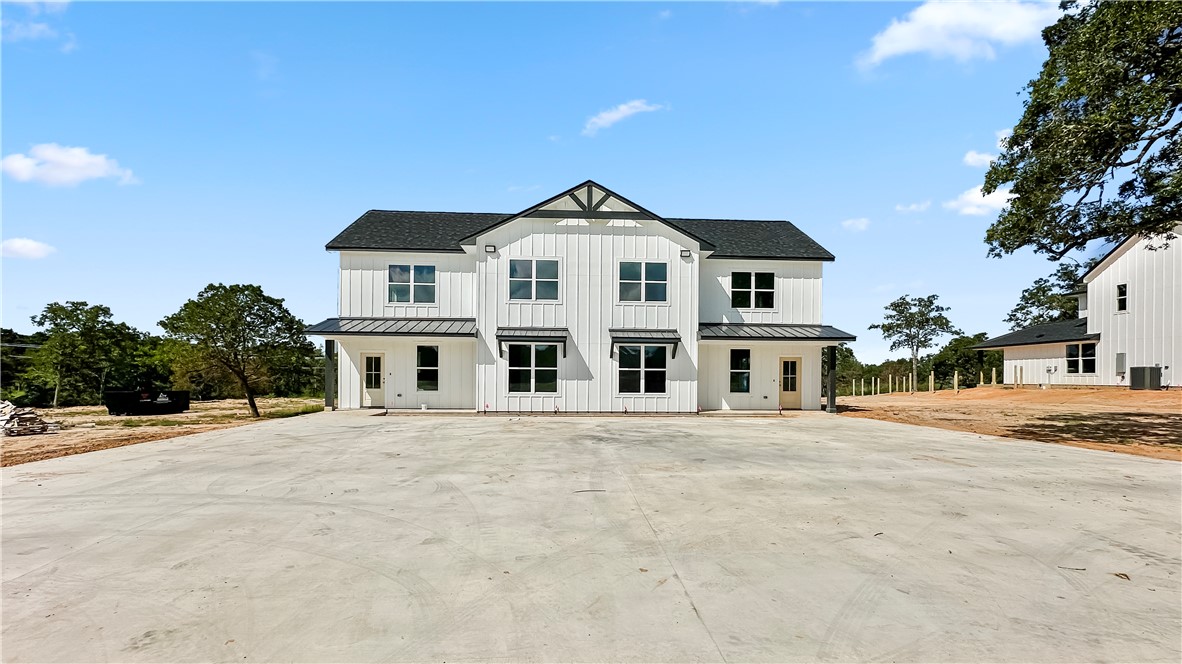 Modern inspired farmhouse with board and batten siding, concrete driveway, and a metal roof