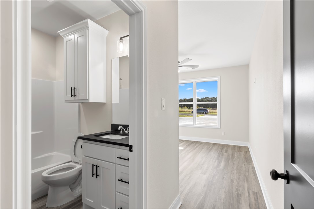 11001-11005 Breedlove Road College Station, TX 77845 - Photo 19 of 40 Full bathroom featuring vanity, shower / washtub combination, light wood-style flooring, and ceiling fan