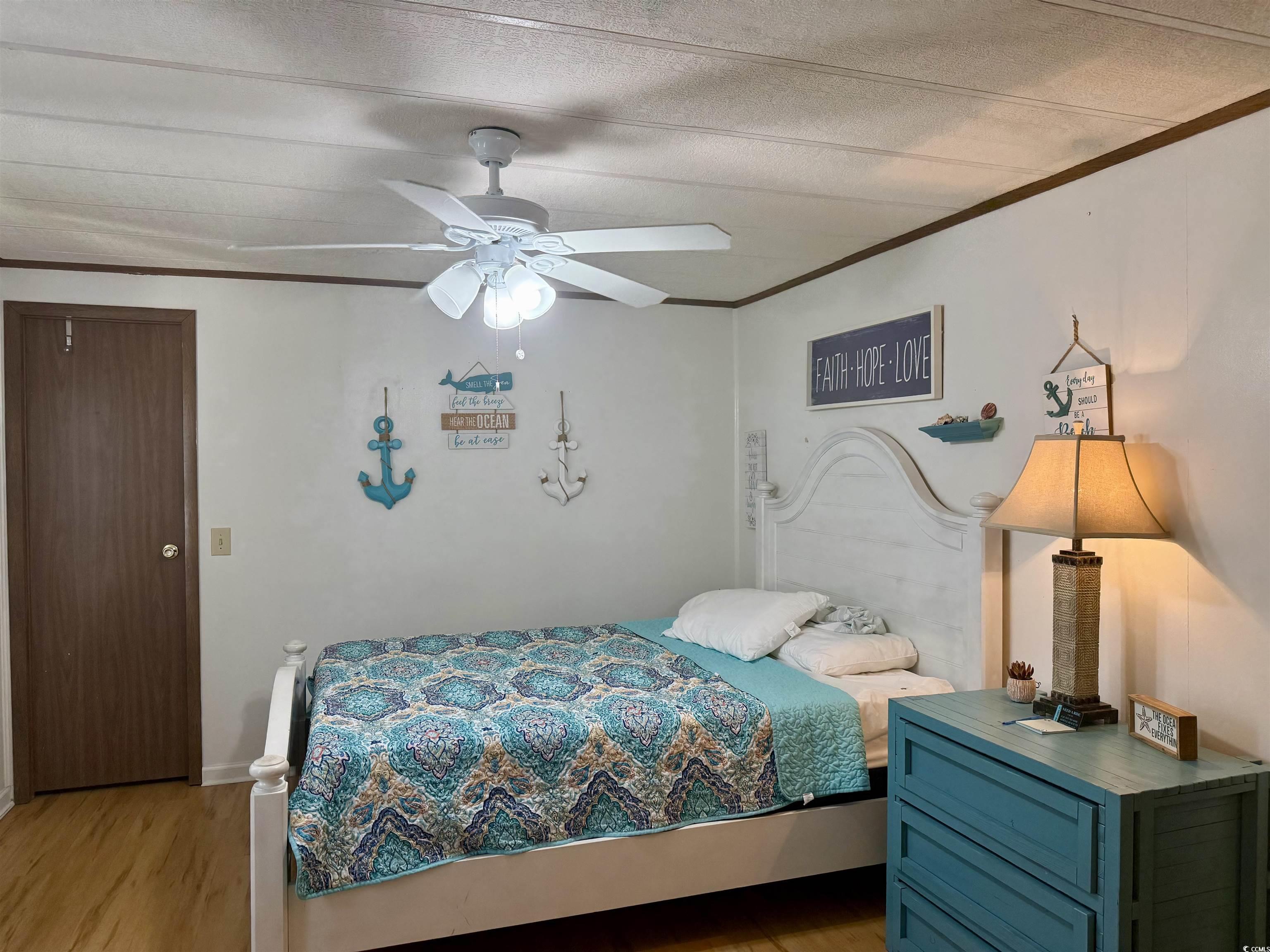 410 E Lake Surfside Beach, SC 29575 - Photo 12 of 27 Bedroom featuring light wood finished floors, ornamental molding, and a ceiling fan