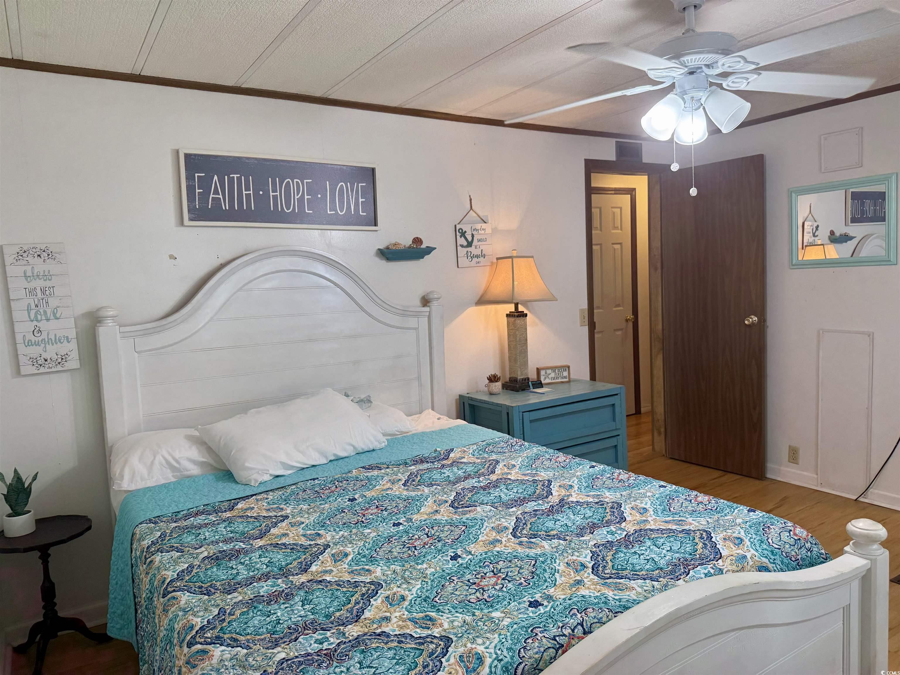410 E Lake Surfside Beach, SC 29575 - Photo 13 of 27 Bedroom with ornamental molding, wood finished floors, and a ceiling fan