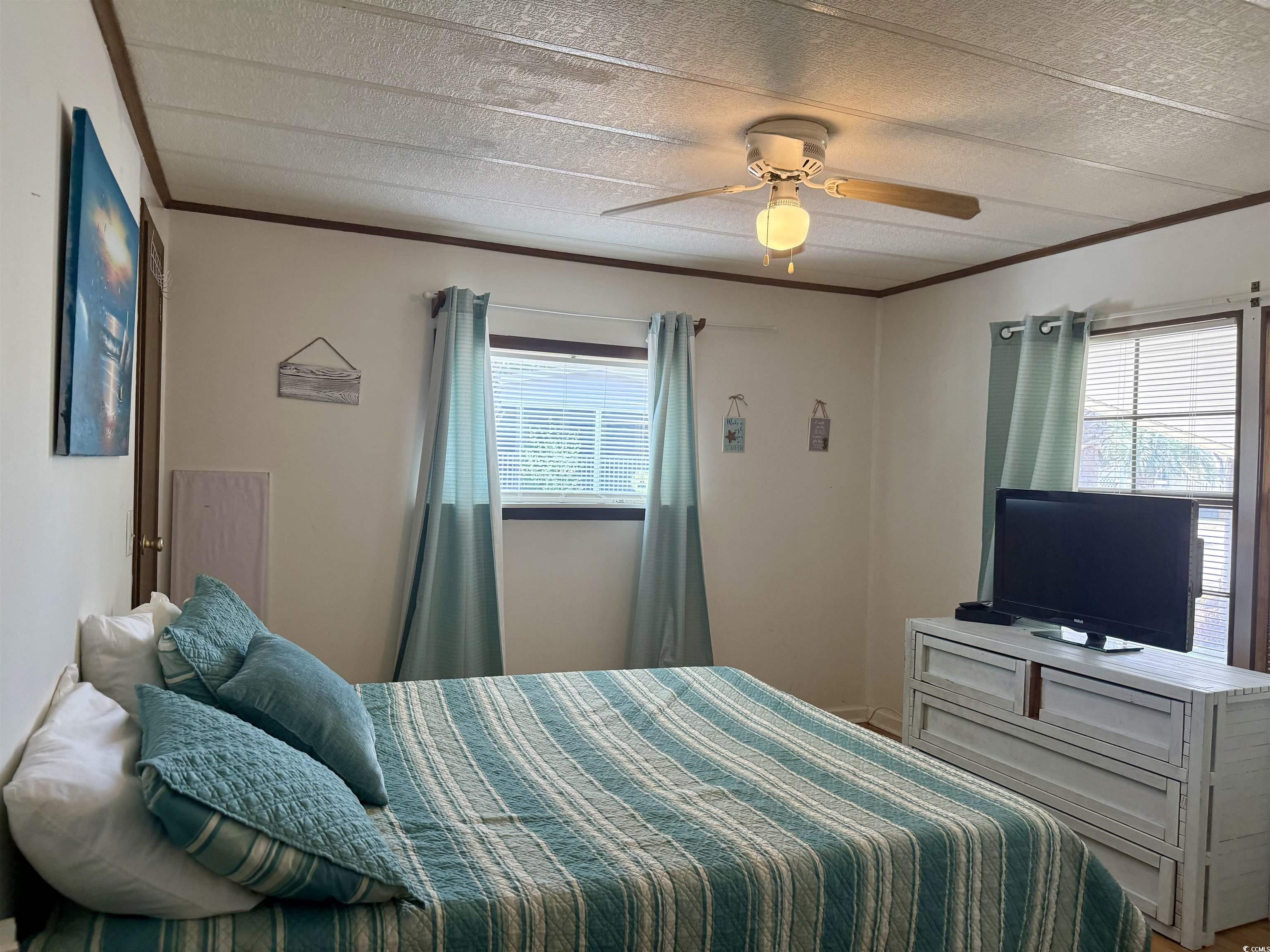 410 E Lake Surfside Beach, SC 29575 - Photo 14 of 27 Bedroom featuring ornamental molding, a ceiling fan, and a textured ceiling