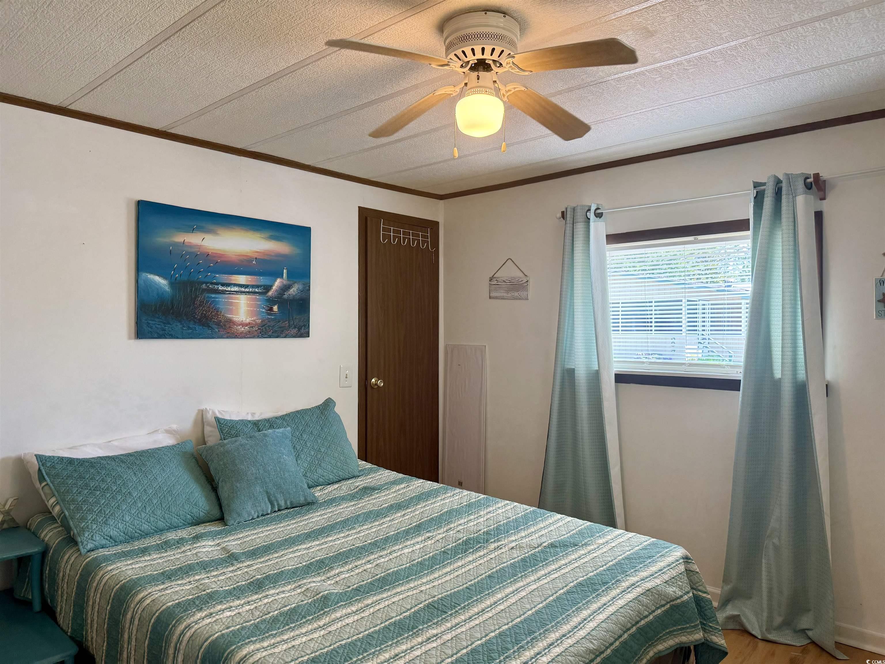 410 E Lake Surfside Beach, SC 29575 - Photo 16 of 27 Bedroom featuring wood finished floors, crown molding, and ceiling fan