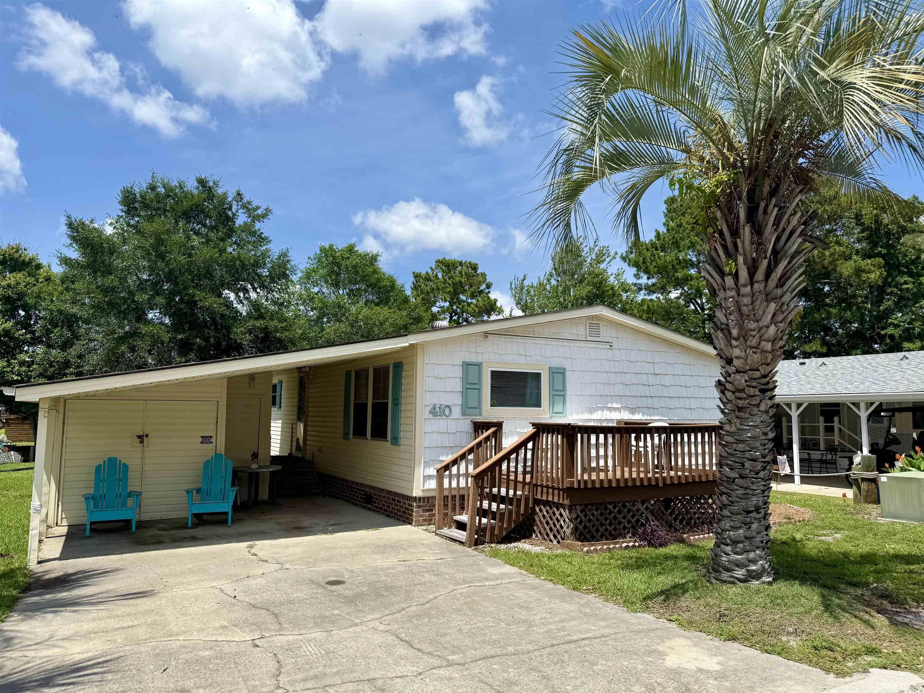 410 E Lake Surfside Beach, SC 29575 - Photo 19 of 27 View of front of home with concrete driveway, a deck, and an attached carport