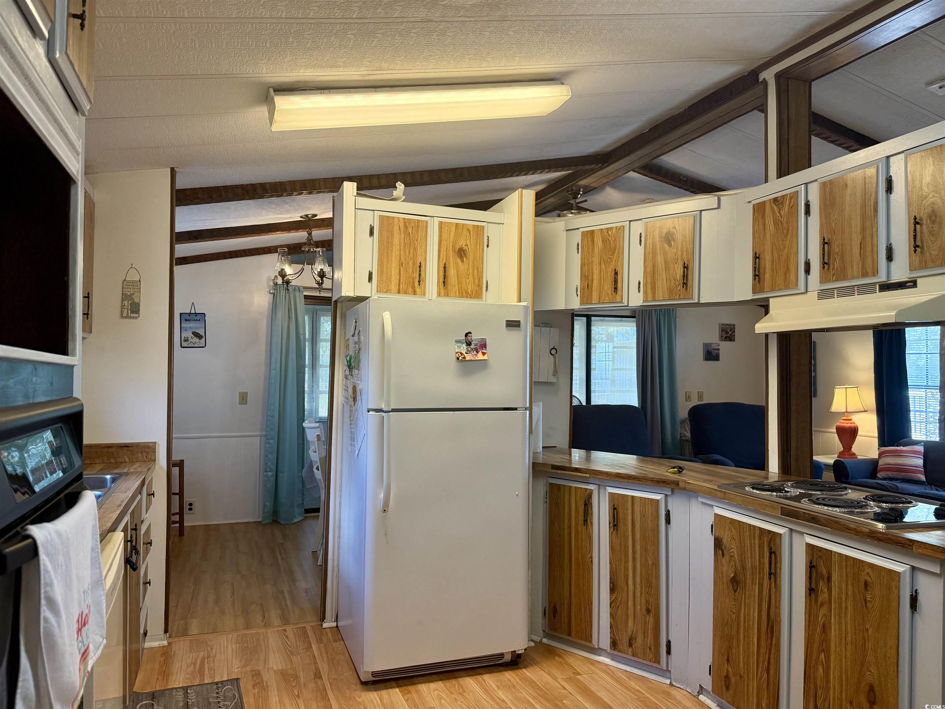 410 E Lake Surfside Beach, SC 29575 - Photo 2 of 27 Kitchen with freestanding refrigerator, light wood-style flooring, stainless steel electric stovetop, and under cabinet range hood