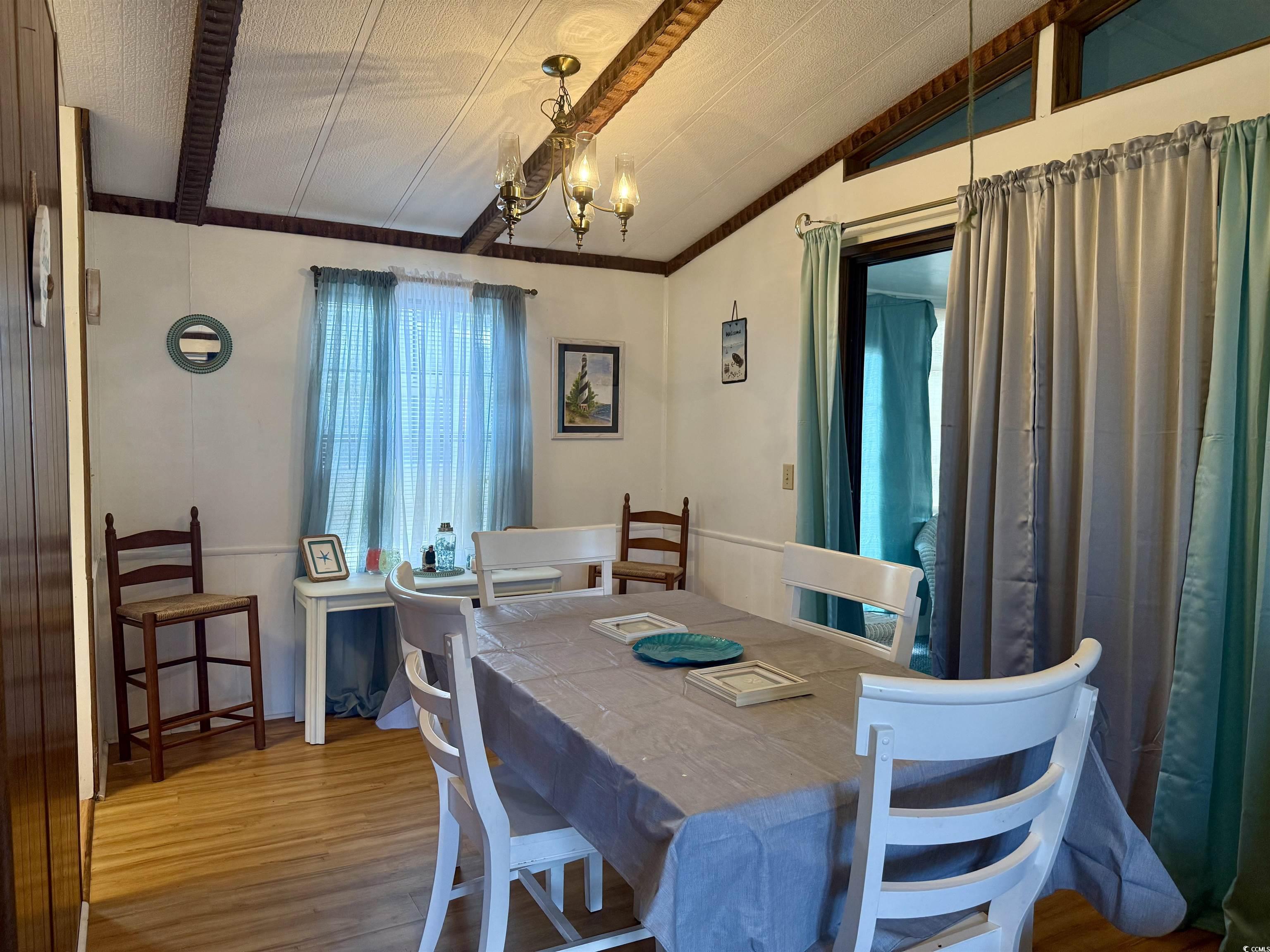 410 E Lake Surfside Beach, SC 29575 - Photo 5 of 27 Dining space with vaulted ceiling, wood finished floors, and a chandelier