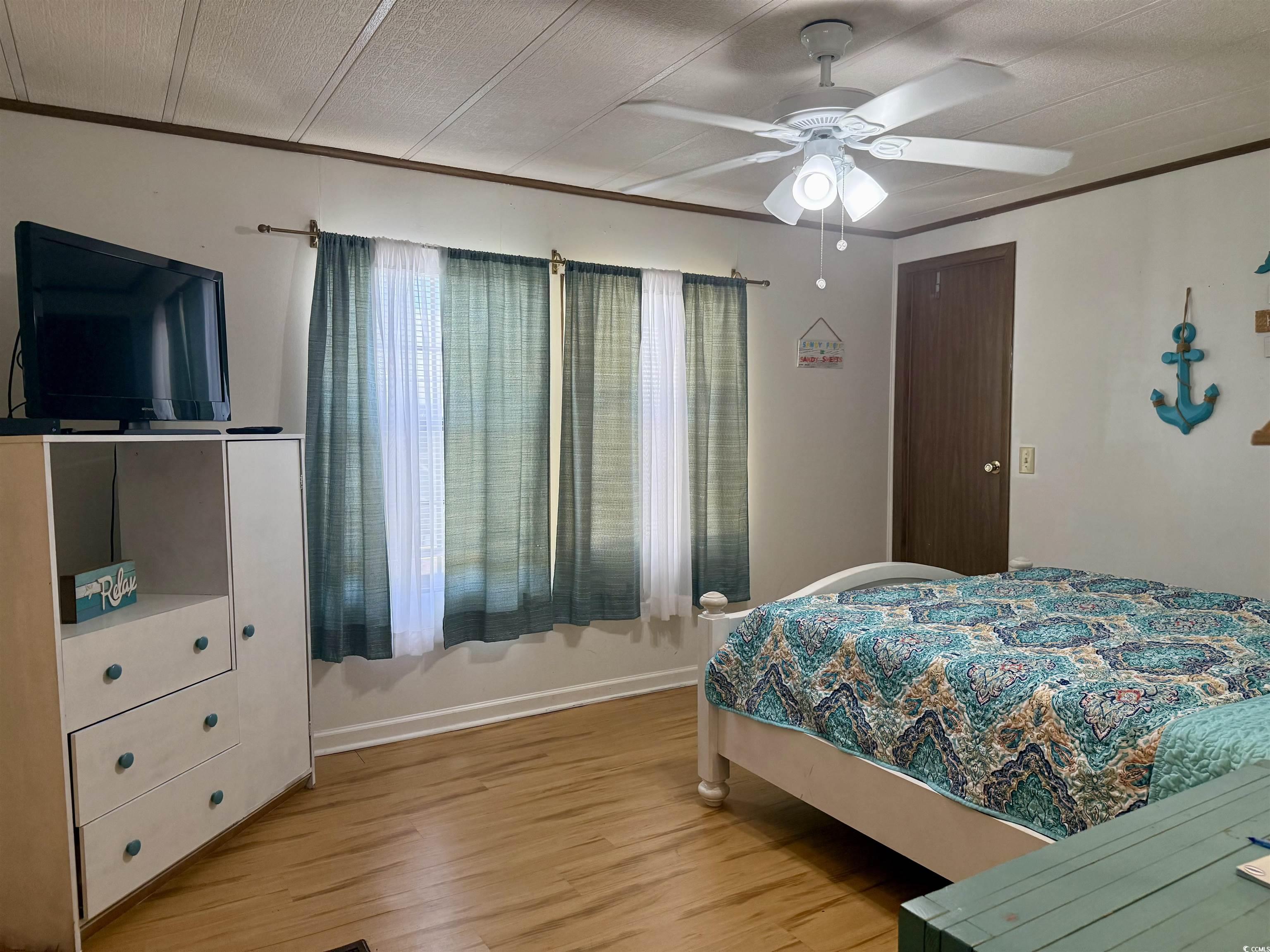 410 E Lake Surfside Beach, SC 29575 - Photo 10 of 27 Bedroom with light wood-style floors, ornamental molding, baseboards, and a ceiling fan
