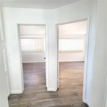 a view of a hallway with wooden floor