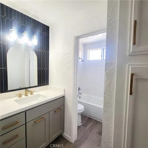 a bathroom with a double vanity sink toilet and shower