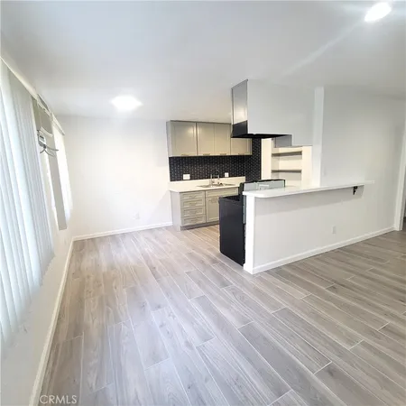 a kitchen with wooden floors and appliances