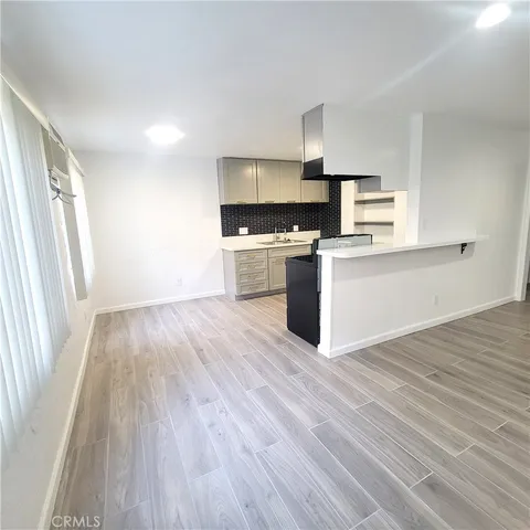 a kitchen with wooden floors and appliances
