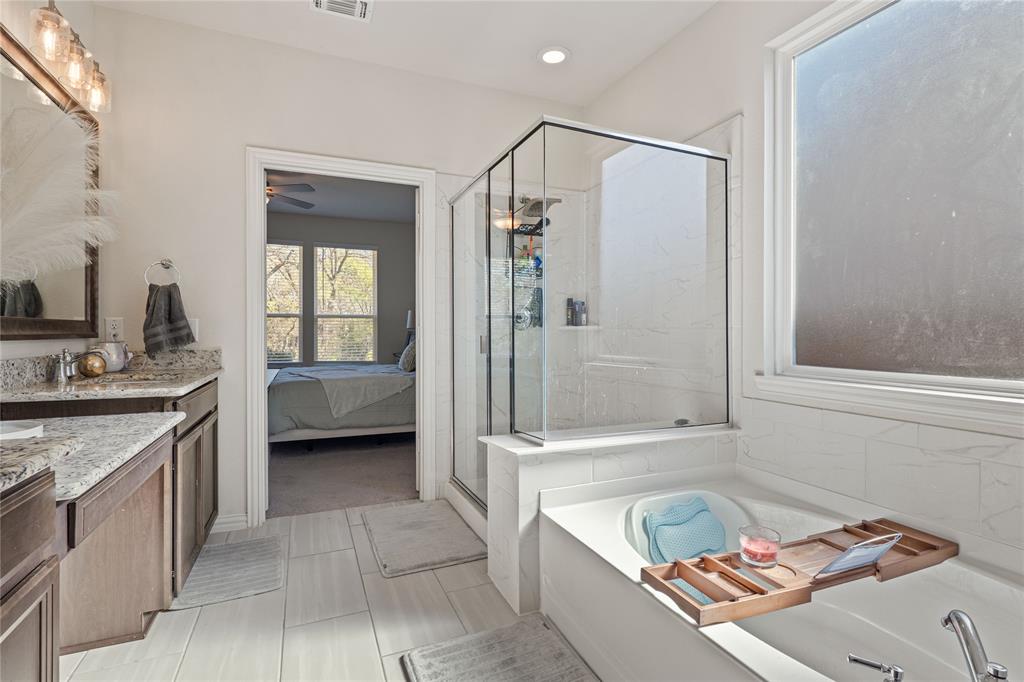 9517 Sunset Lane Oak Point, TX 75068 - Photo 24 of 40 9517 Sunset Lane, Oak Point, TX 75068 - primary bathroom - primary bathroom with vanity, a garden tub, and a shower stall