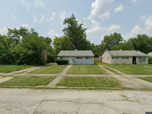 a view of a house with a yard and large trees