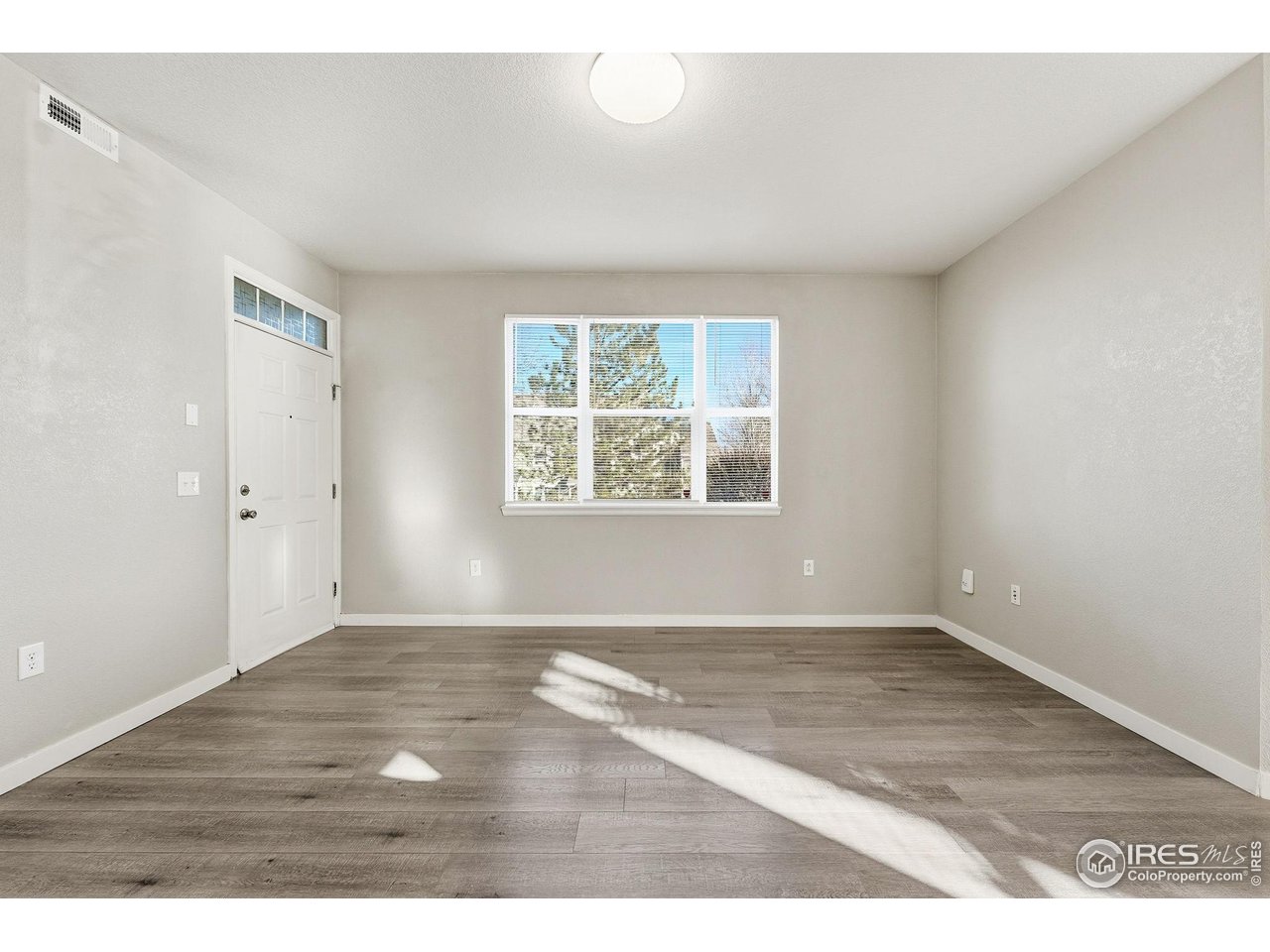 4501 Nelson Road, Unit 2404 Longmont, CO 80503 - Photo 12 of 23 an empty room with wooden floor and windows