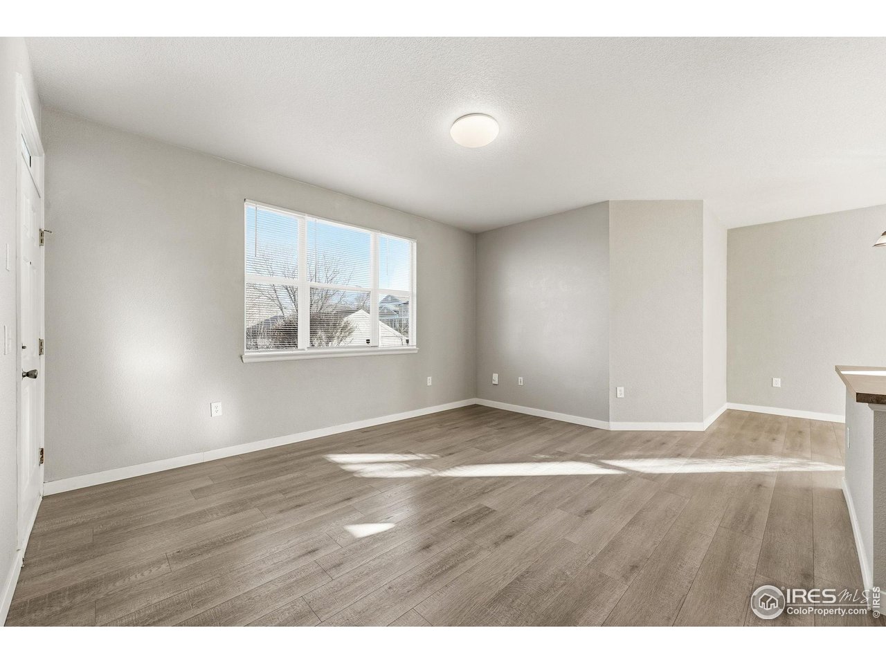 4501 Nelson Road, Unit 2404 Longmont, CO 80503 - Photo 13 of 23 a view of an empty room with wooden floor and a window