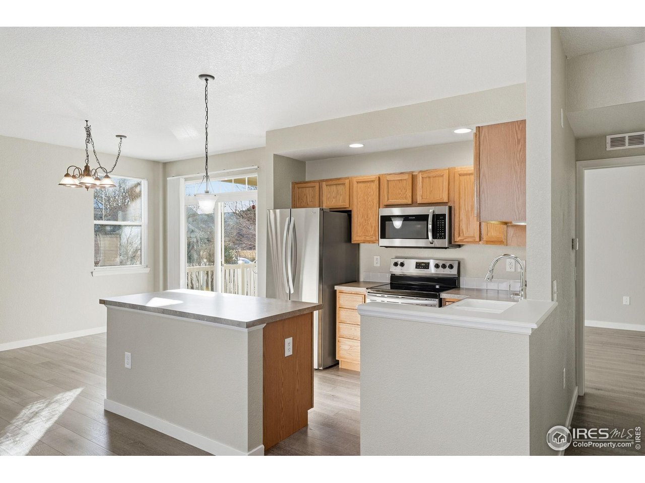 4501 Nelson Road, Unit 2404 Longmont, CO 80503 - Photo 5 of 23 a kitchen with stainless steel appliances a sink a stove a refrigerator cabinets and a window