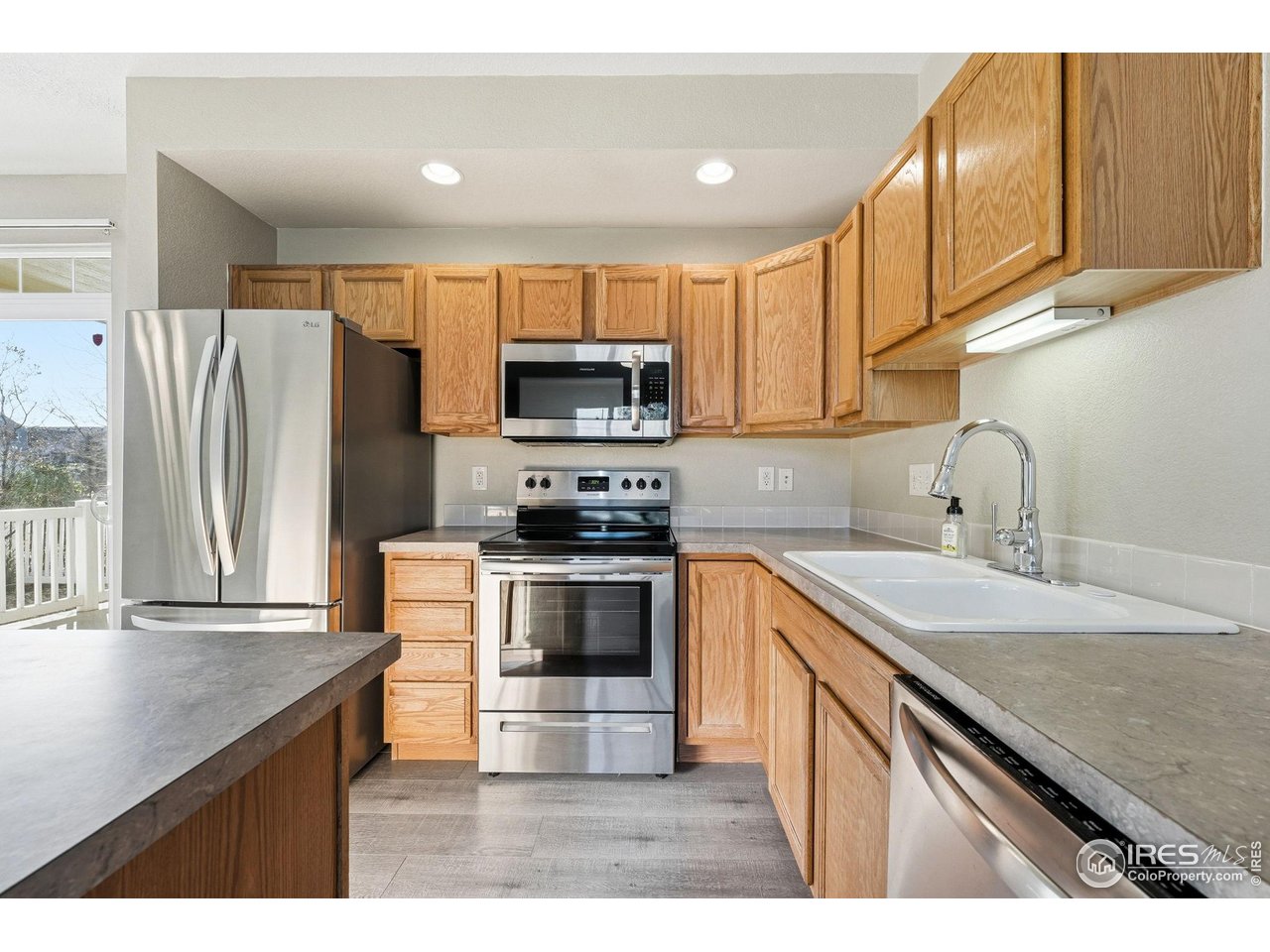 4501 Nelson Road, Unit 2404 Longmont, CO 80503 - Photo 6 of 23 a kitchen with kitchen island granite countertop a sink stove and refrigerator