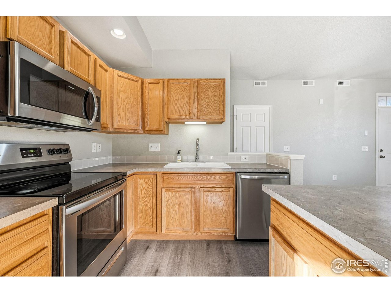 4501 Nelson Road, Unit 2404 Longmont, CO 80503 - Photo 7 of 23 a kitchen with stainless steel appliances granite countertop a stove a sink and a microwave