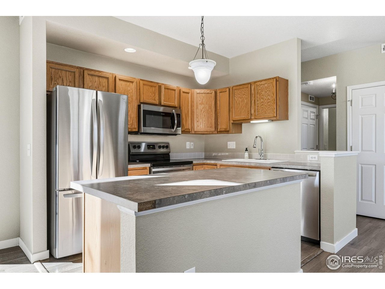 4501 Nelson Road, Unit 2404 Longmont, CO 80503 - Photo 8 of 23 a kitchen with kitchen island a counter top space stainless steel appliances and cabinets