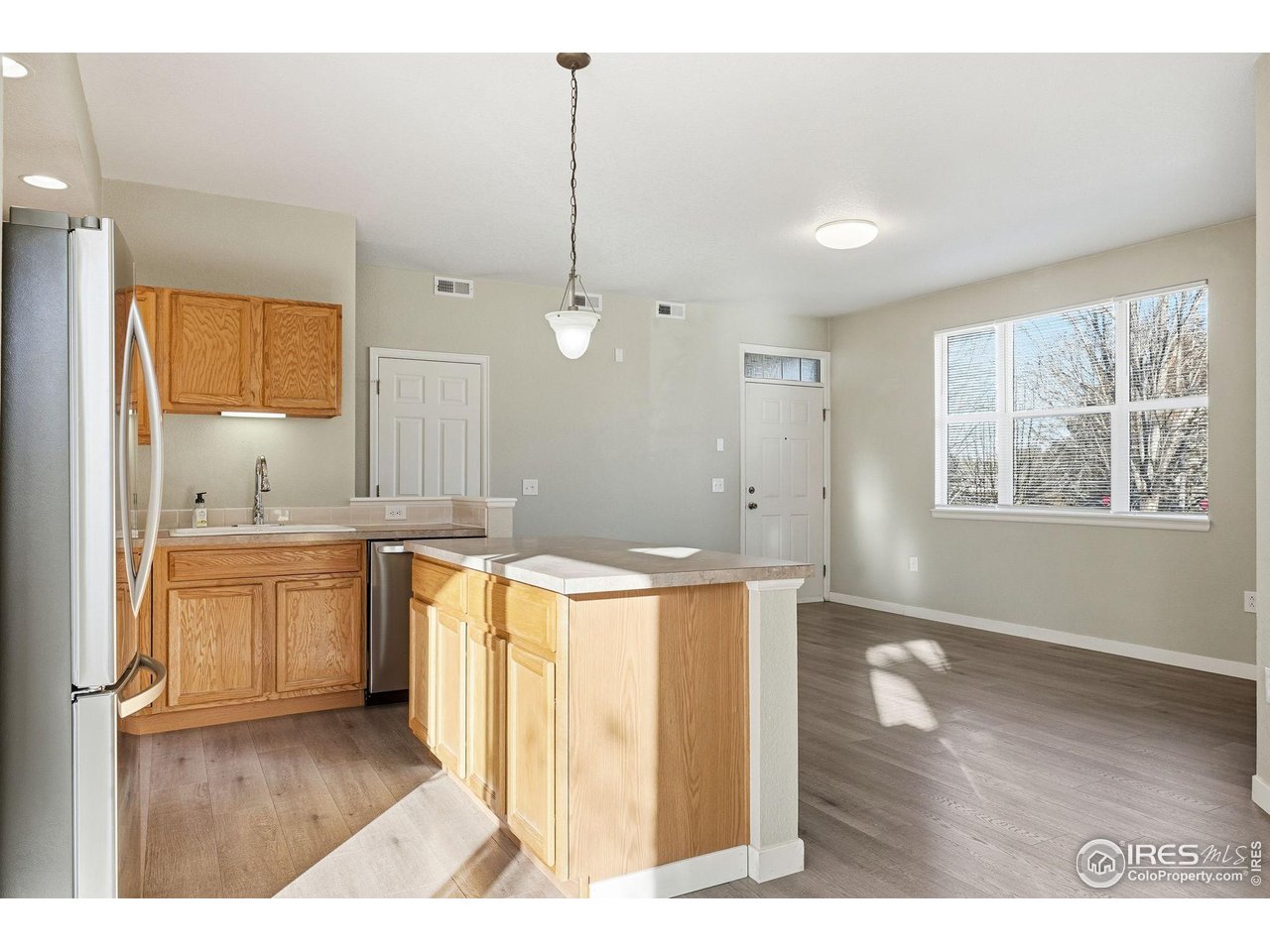 4501 Nelson Road, Unit 2404 Longmont, CO 80503 - Photo 10 of 23 a kitchen with a refrigerator a sink and wooden floor