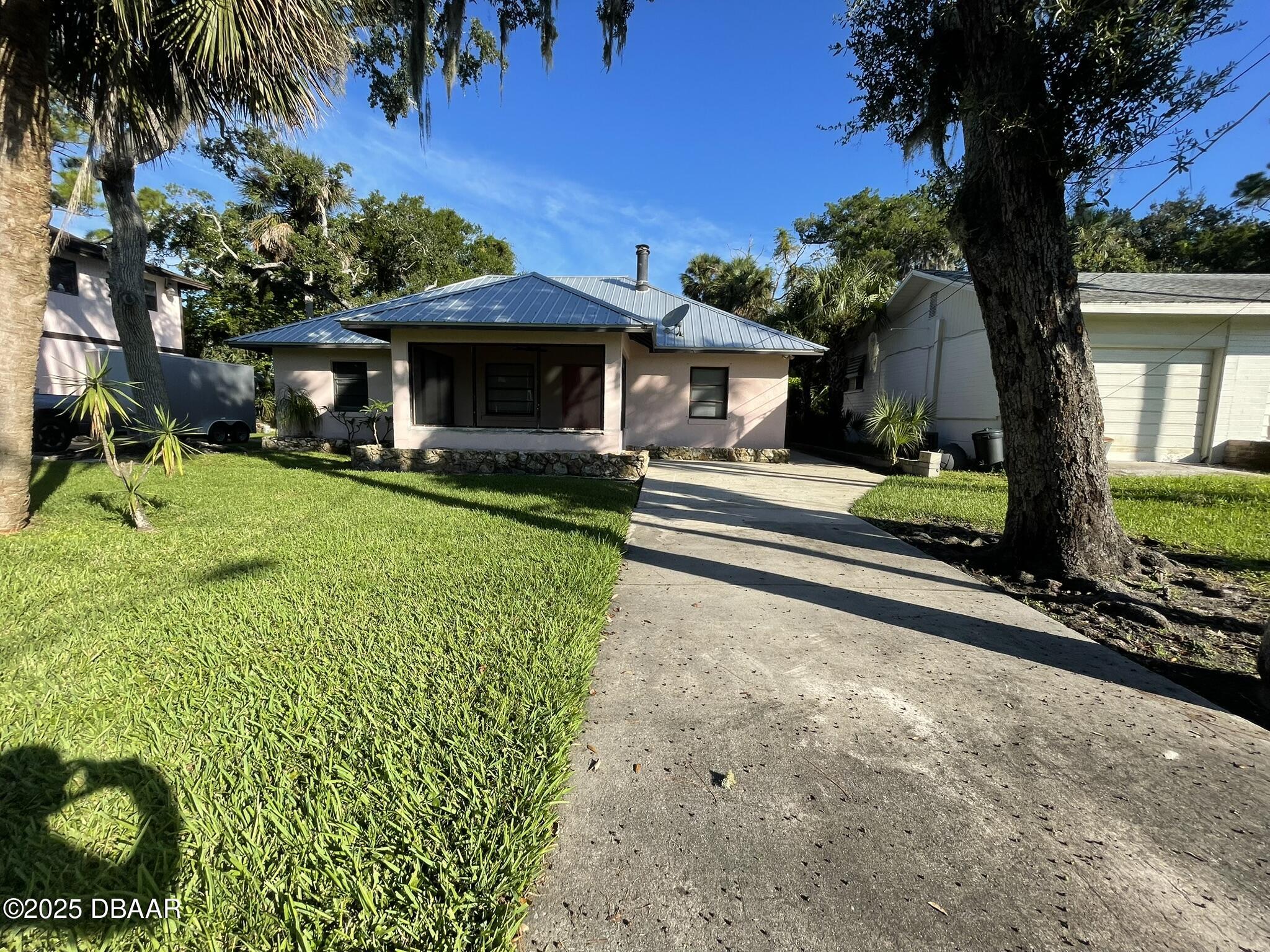 a front view of a house with a yard and potted plants