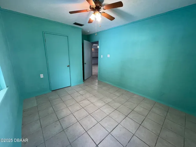 an empty room with closet and fan