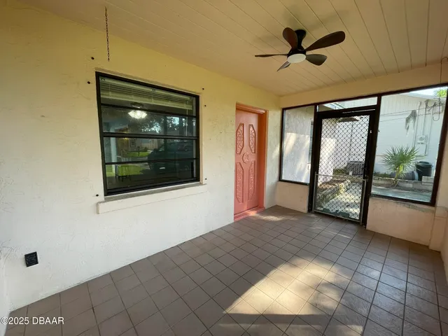 a view of a livingroom with a ceiling fan and window