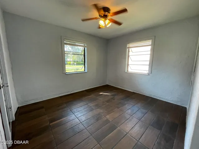 a view of an empty room with a chandelier fan