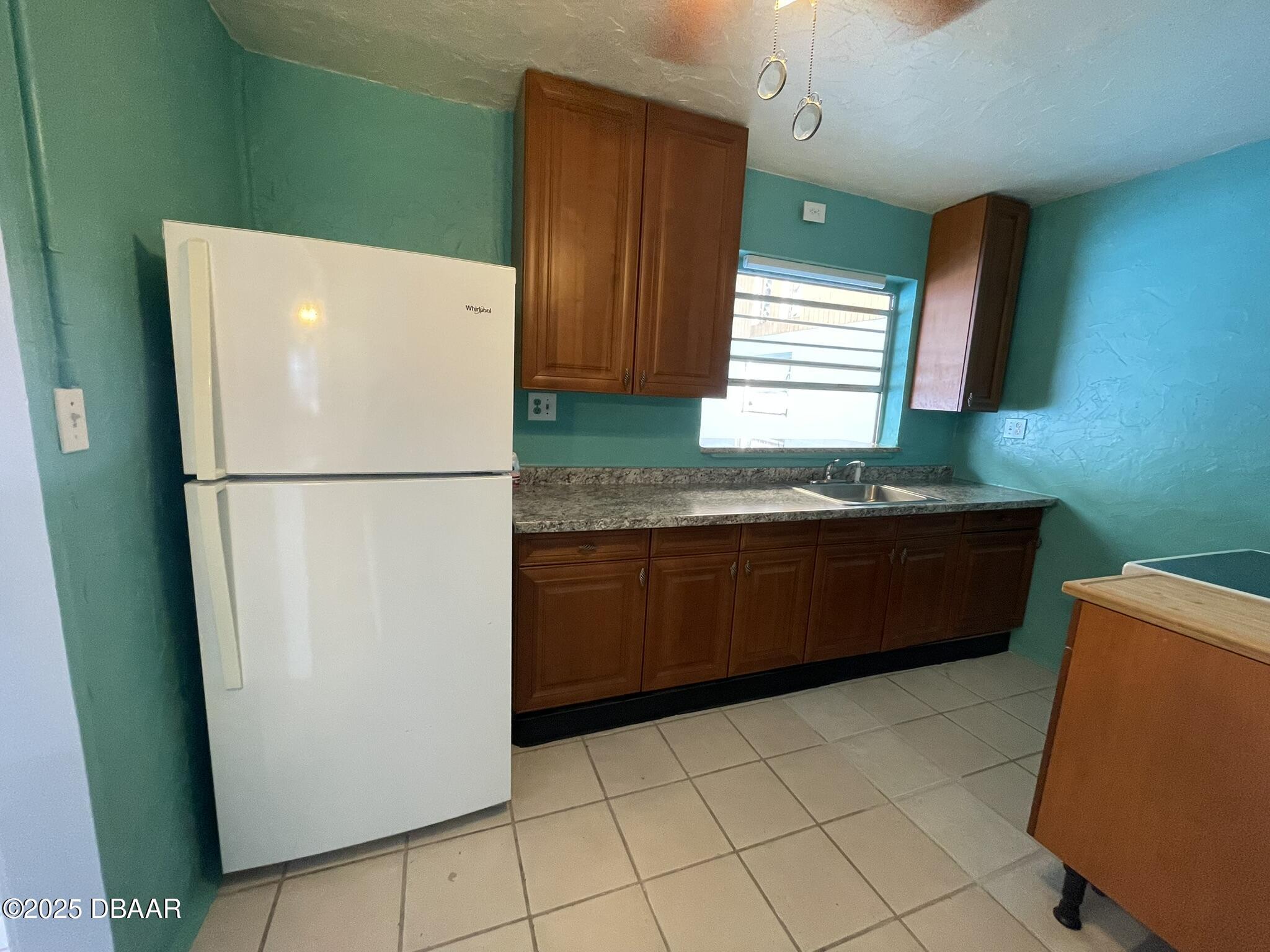 113 Fox Place Port Orange, FL 32127 - Photo 7 of 40 a kitchen with a refrigerator and a sink