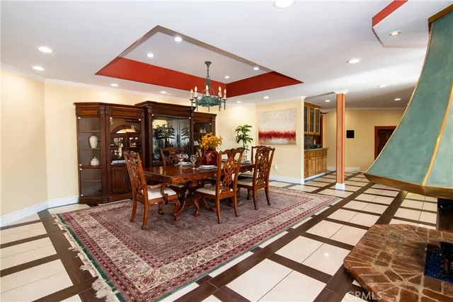 a kitchen with stainless steel appliances kitchen island granite countertop a stove top oven a sink dishwasher a dining table and chairs with wooden floor