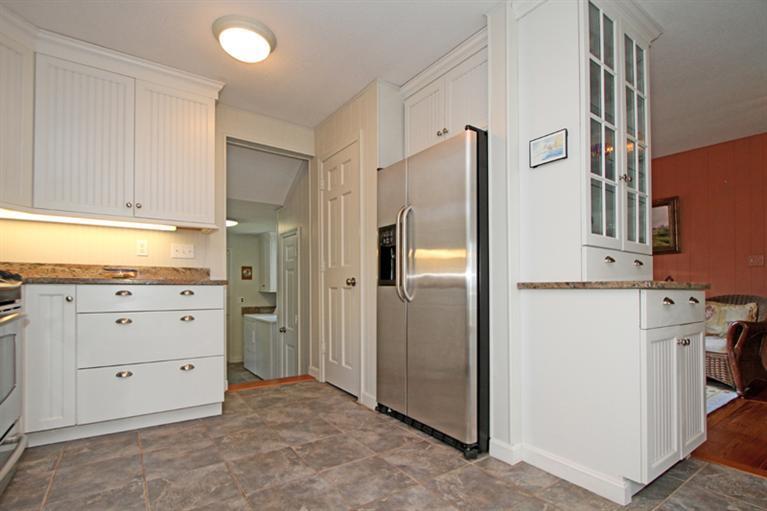 505 Scraggy Neck Road Cataumet, MA 02534 - Photo 11 of 33 a kitchen with white cabinets and refrigerator
