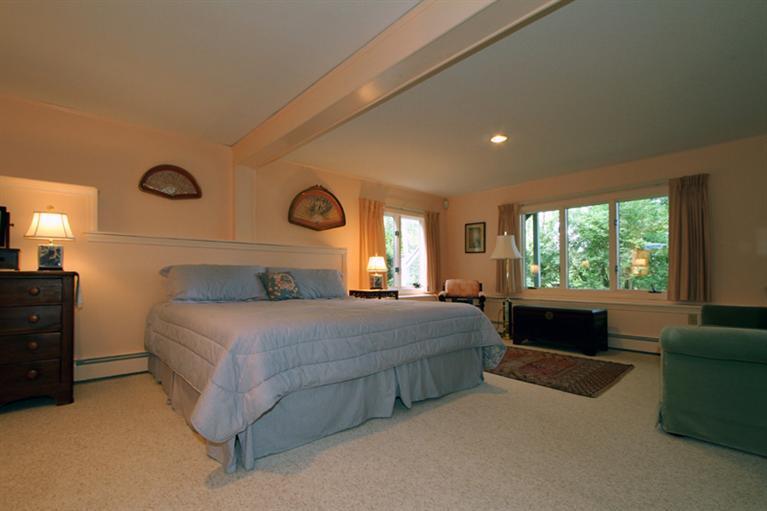 505 Scraggy Neck Road Cataumet, MA 02534 - Photo 16 of 33 a bedroom with a large bed and a large window