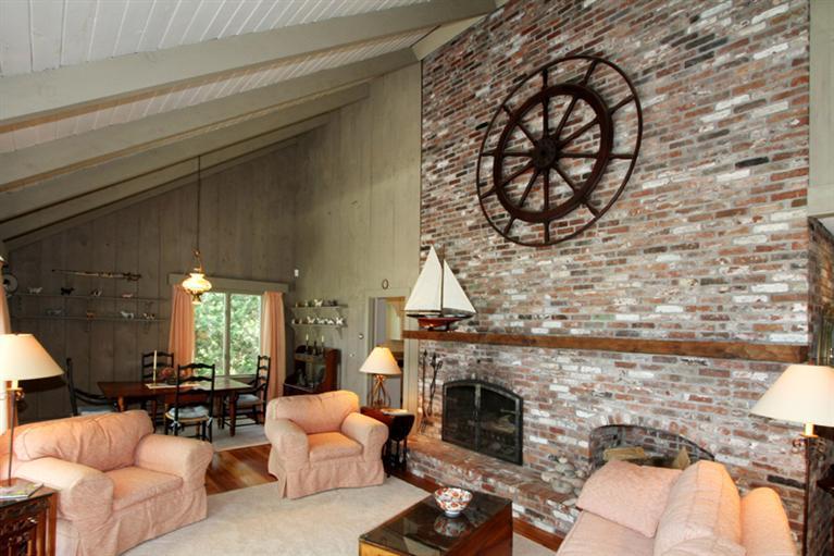 505 Scraggy Neck Road Cataumet, MA 02534 - Photo 4 of 33 a living room with furniture a fireplace and a floor to ceiling window
